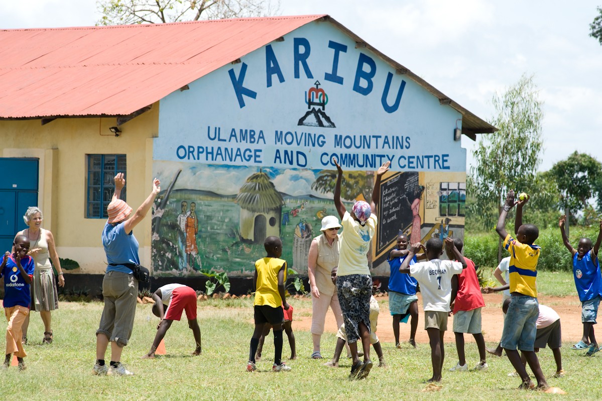 Volunteers and children taking part in activities outside a community centre in Kenya